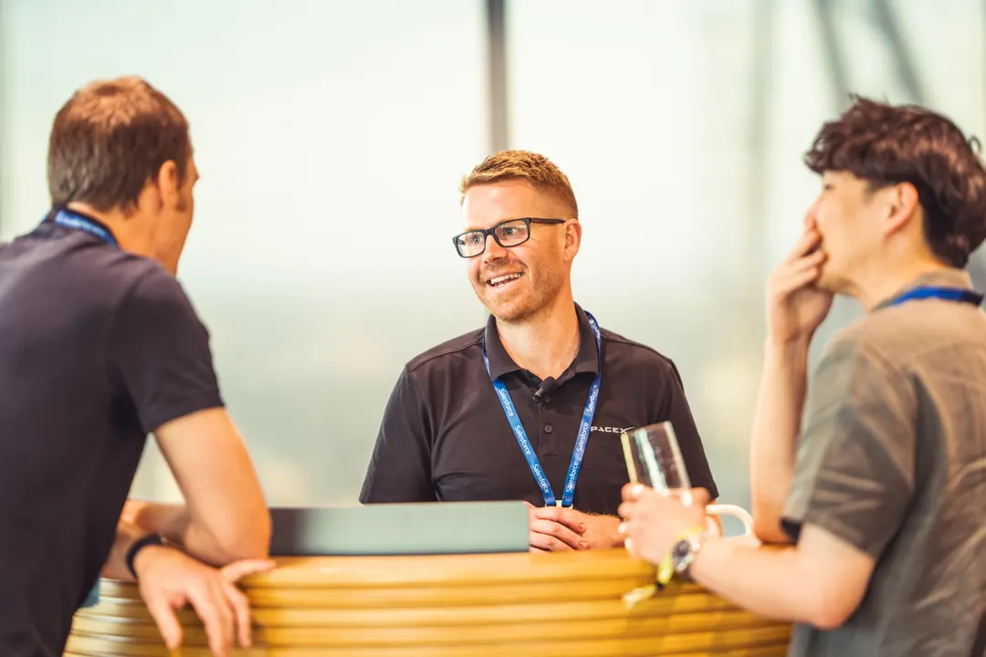 Attendees in conversation at a standing table