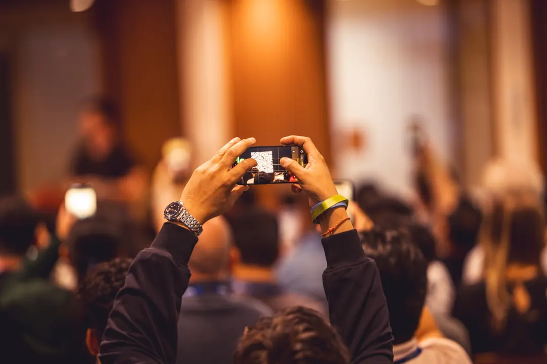 Attendee photographing a slide on their phone